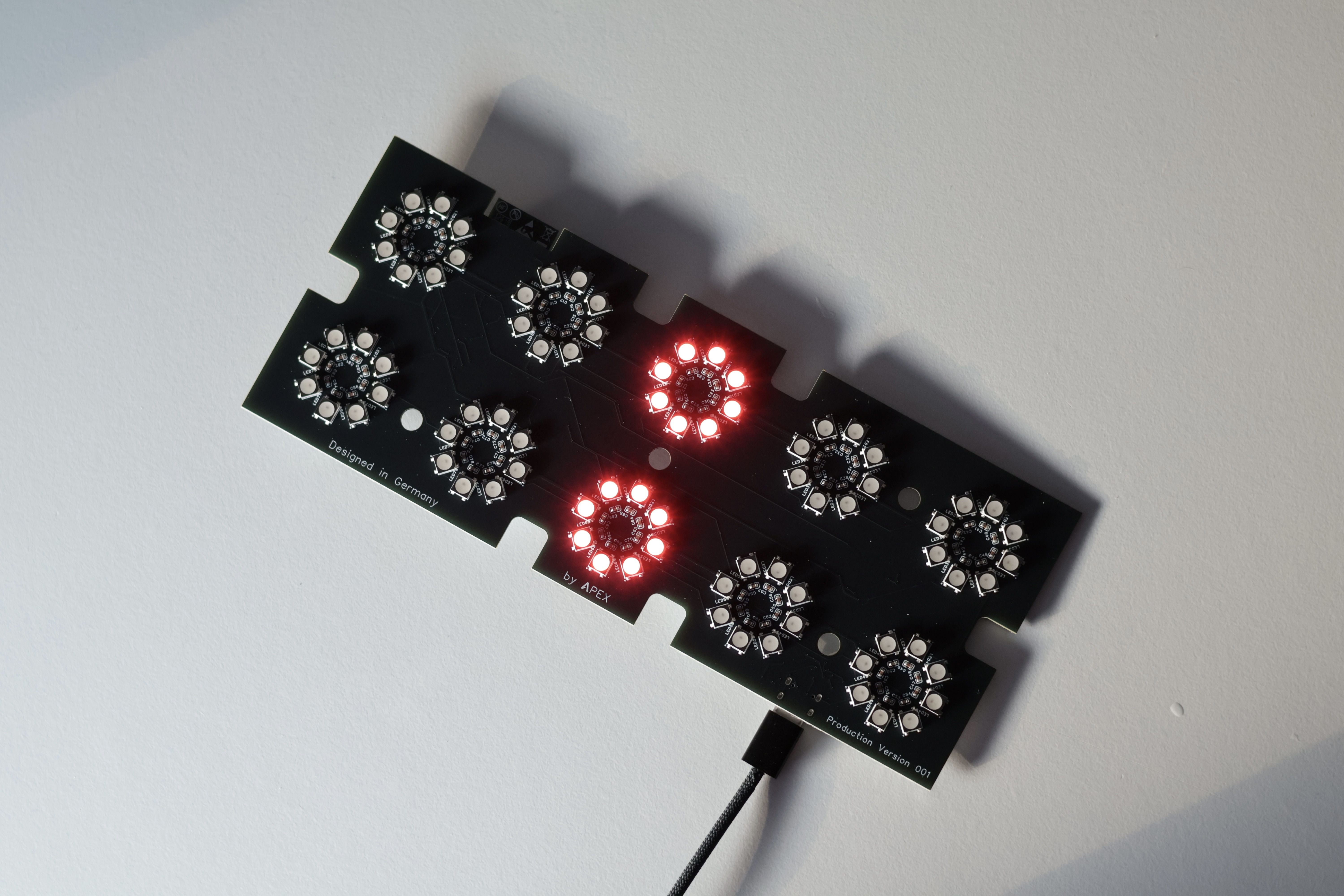 Final APEX all-in-one printed circuit board with integrated LED electronics, partially illuminated in red